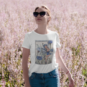 Young woman in a field of pink flowers wearing white t-shirt with Cornflower fairy print